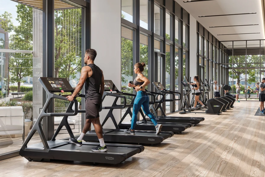 People exercising on treadmills in a modern gym with large floor-to-ceiling windows