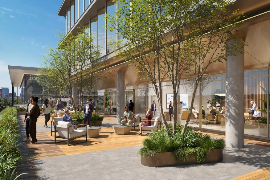 Office outdoor patio area featuring people socializing and working in a landscaped environment